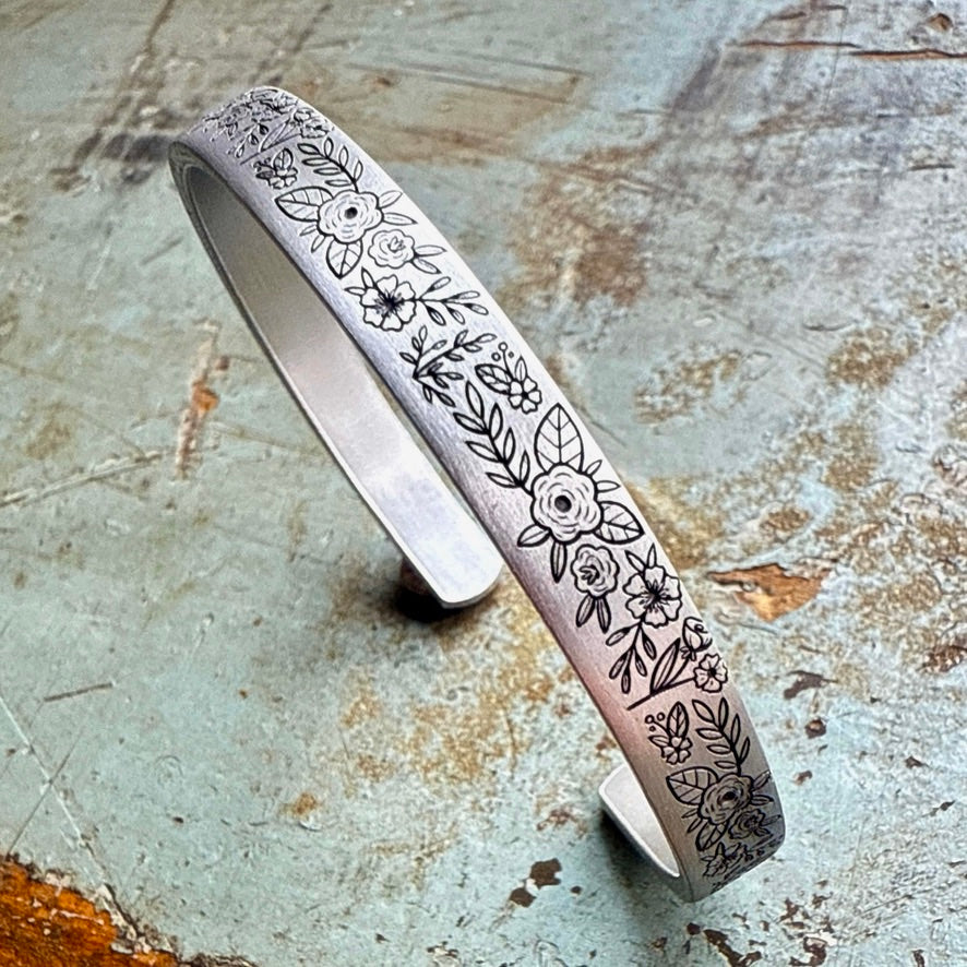 Silver bangle with floral patterns with inside message