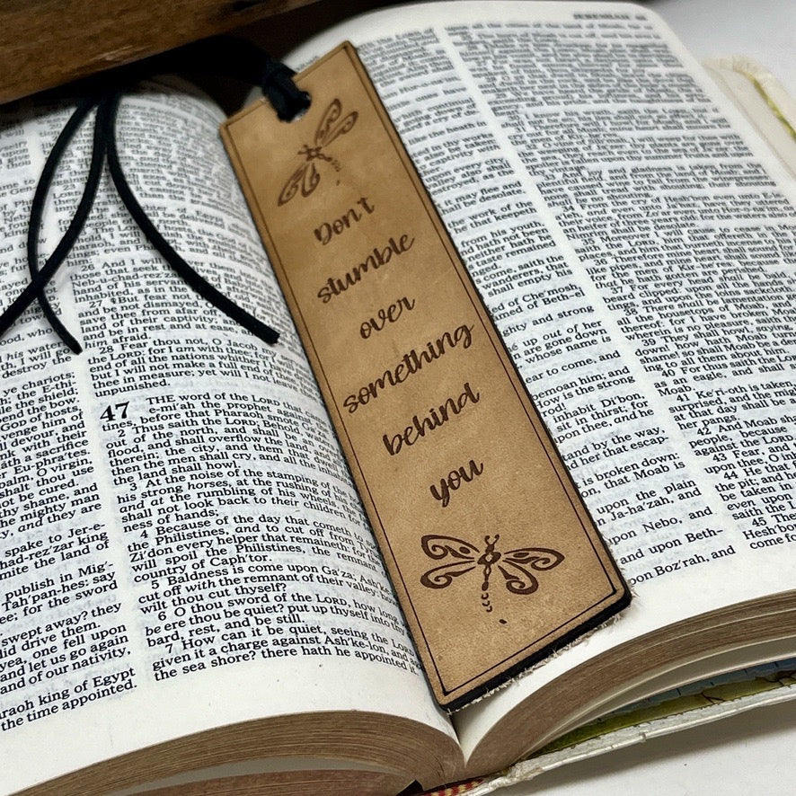Bookmark with motivational quote and dragonfly on an open book