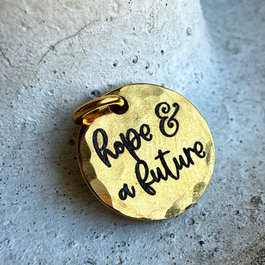 gold charm with engraved with hope & a future