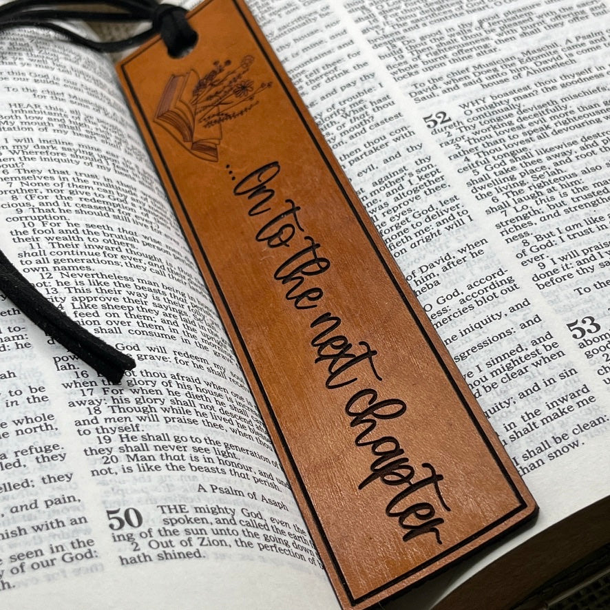 Brown leather bookmark with 'On to the next chapter' text on an open book.