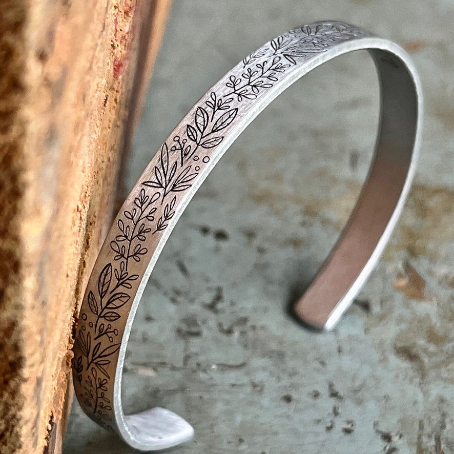 Silver bracelet with leaf pattern and interior message