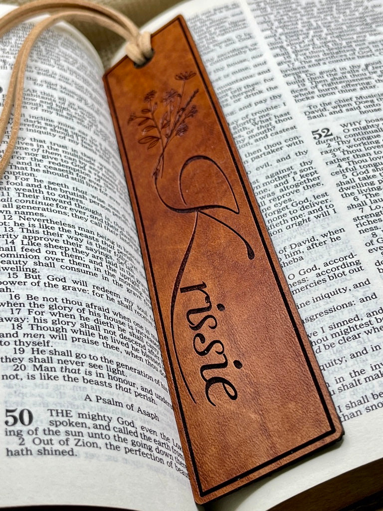 Brown leather bookmark with name engraved on an open book