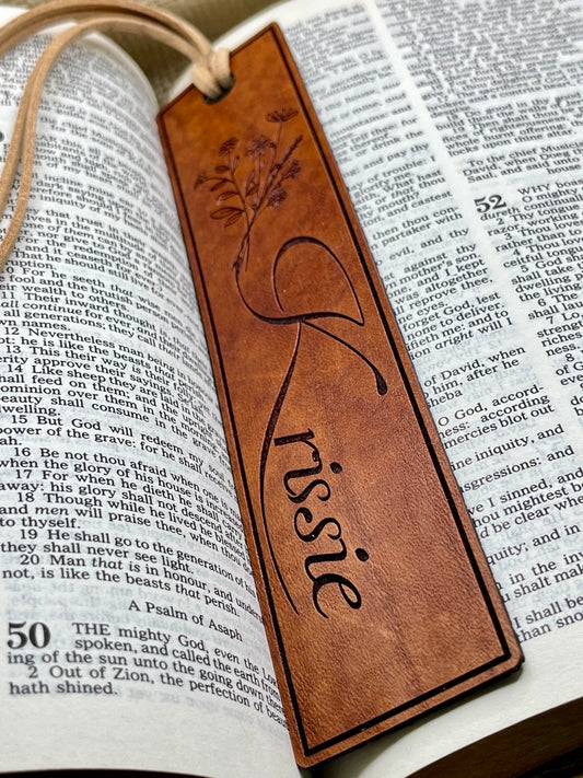 Brown leather bookmark with name engraved on an open book