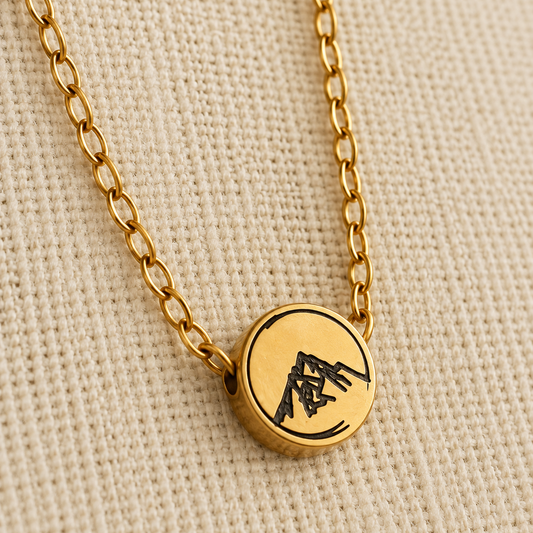 gold charm necklace with mountain engraved design